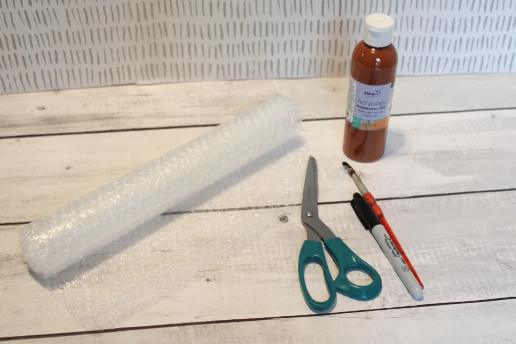 Bubble wrap, scissors, brown paint, and Sharpie ready for creating the cone stamp.