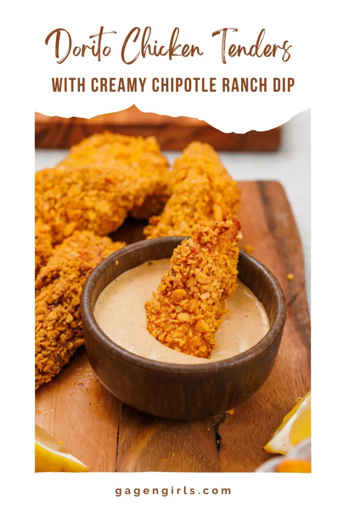 A crispy Dorito chicken tender dipped into creamy chipotle ranch dressing in a wooden bowl.