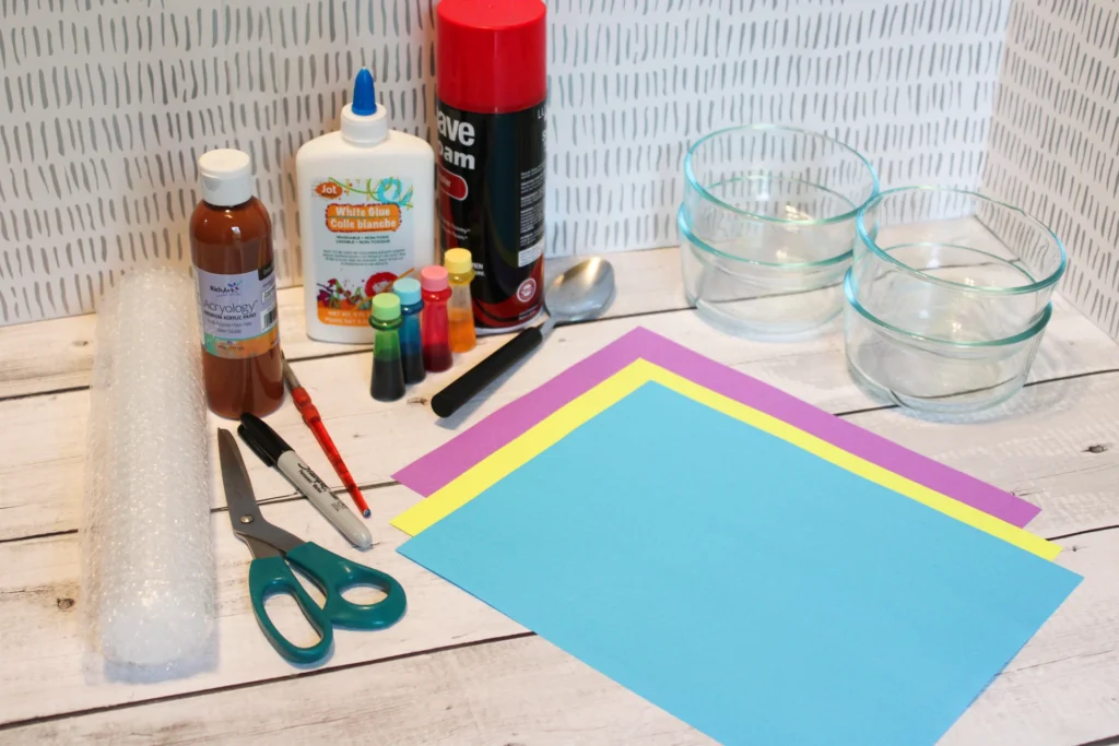 All supplies laid out for the Puffy Paint Ice Cream craft, including glue, shaving cream, food coloring, paper, and bubble wrap.