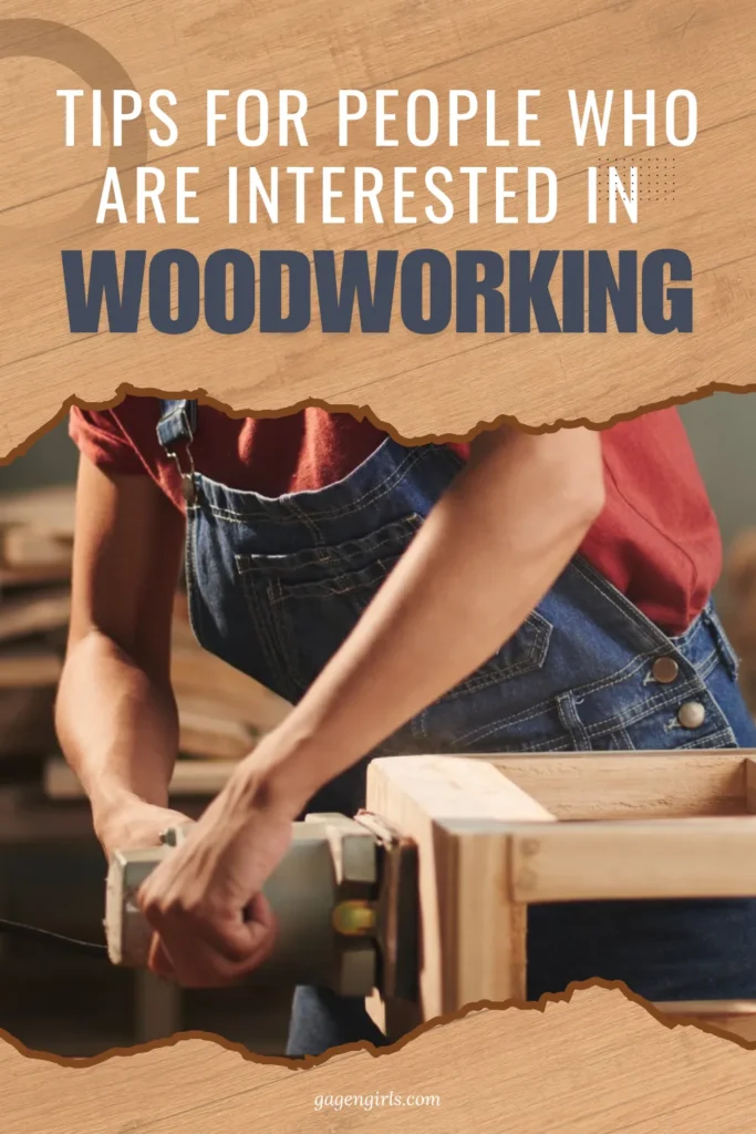A woman in denim overalls focused on sanding a wooden frame in a woodworking shop.