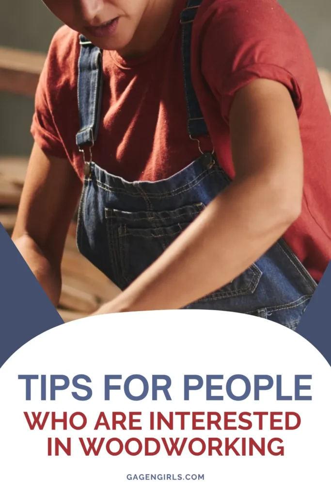Close-up of a person shaping wood with a power tool, wearing a red shirt and overalls.