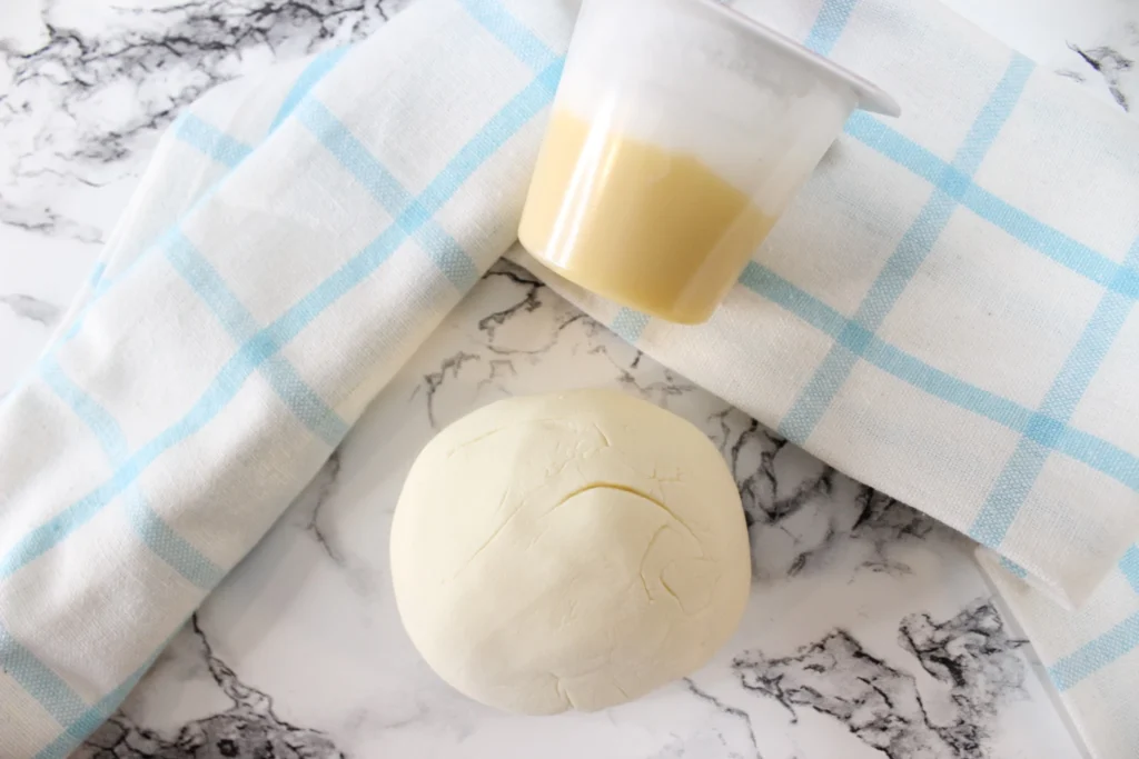 Homemade pudding play dough beside a banana pudding cup and kitchen cloth