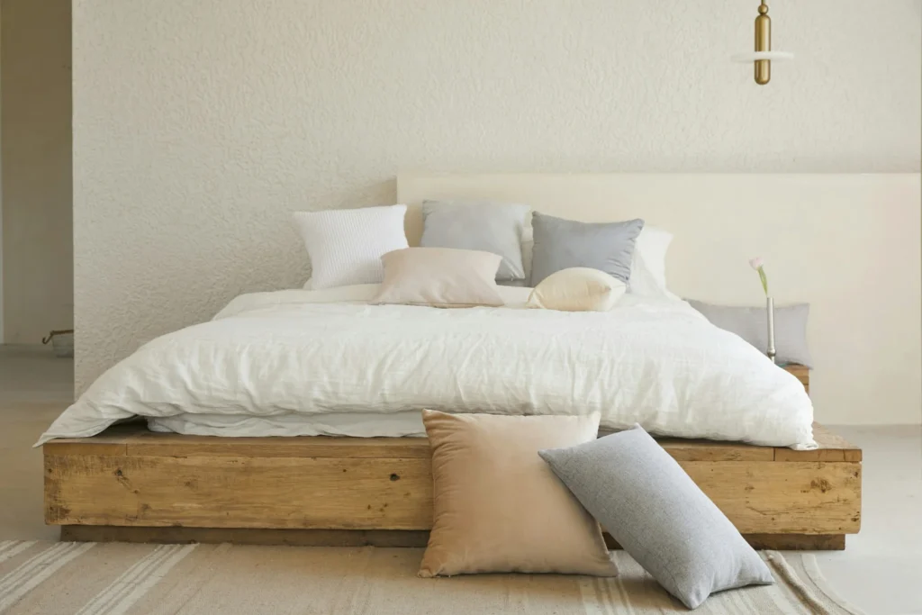 Minimalist bedroom with clean white bedding and pillows, representing a hypoallergenic sleep environment for allergy relief