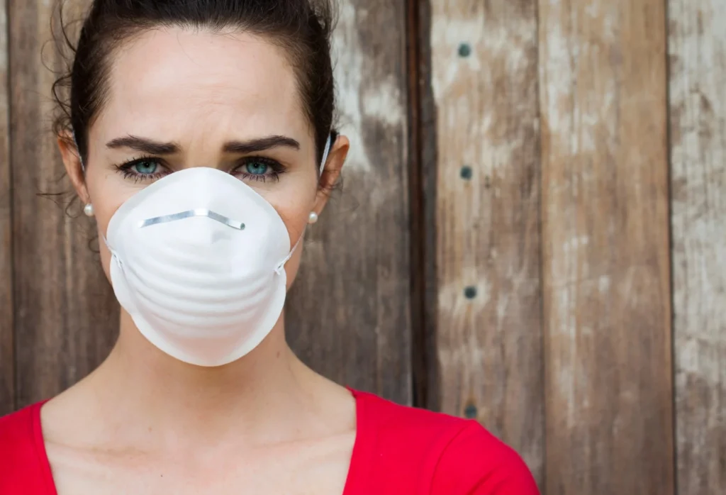 Woman wearing a protective mask outdoors to reduce exposure to pollen and seasonal allergens