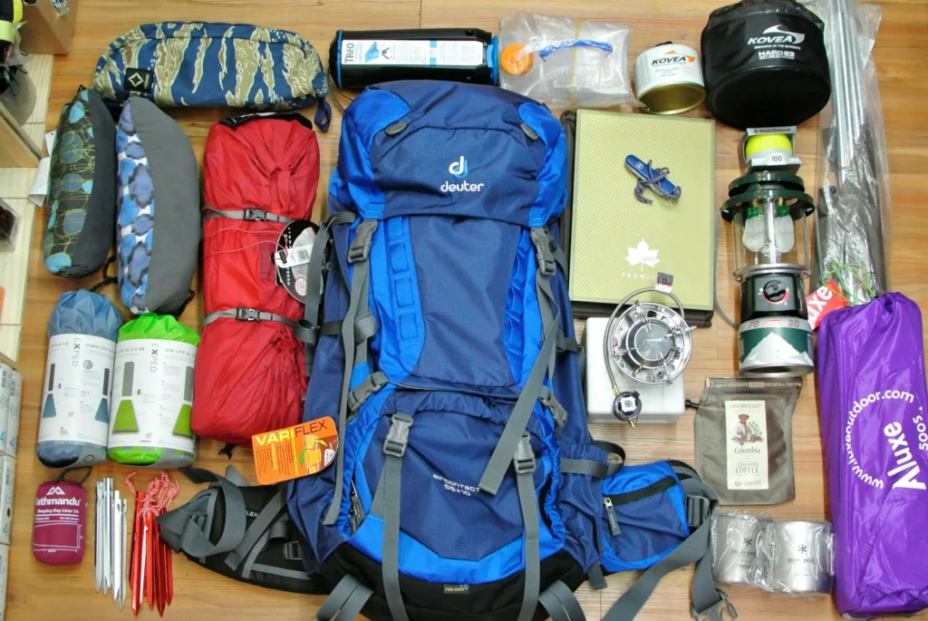 Camping gear and supplies laid out neatly on the floor for packing and organization.