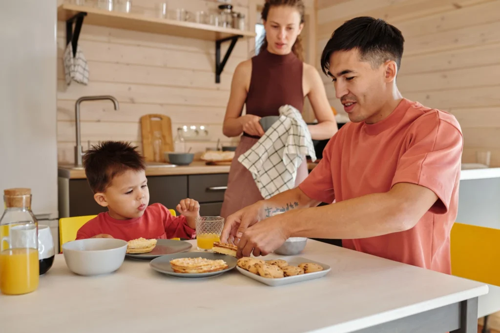 Parent and child having breakfast together in a modern kitchen.