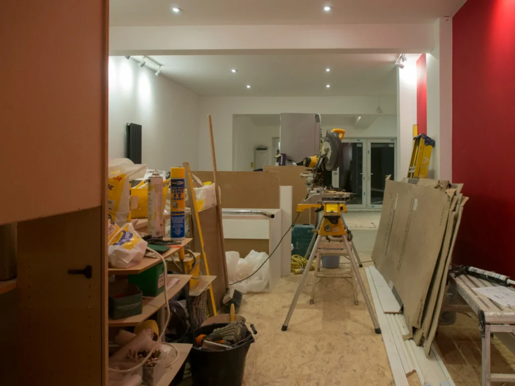 Home renovation workspace with construction tools, building materials, and unfinished interior.