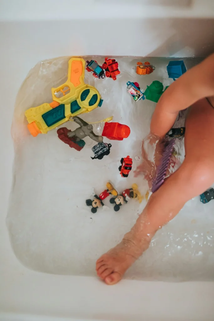 Child playing with toy figures and bath toys during a rainy day indoor activity.