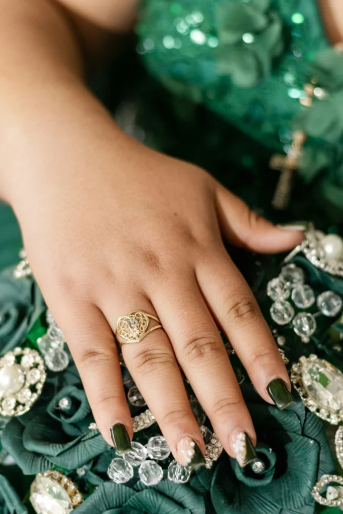 Young woman's hand wearing a gold heart ring at a quinceañera