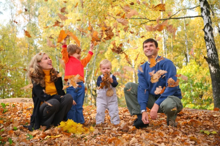 Family playing together in autumn leaves for 15 minutes of family fun in November