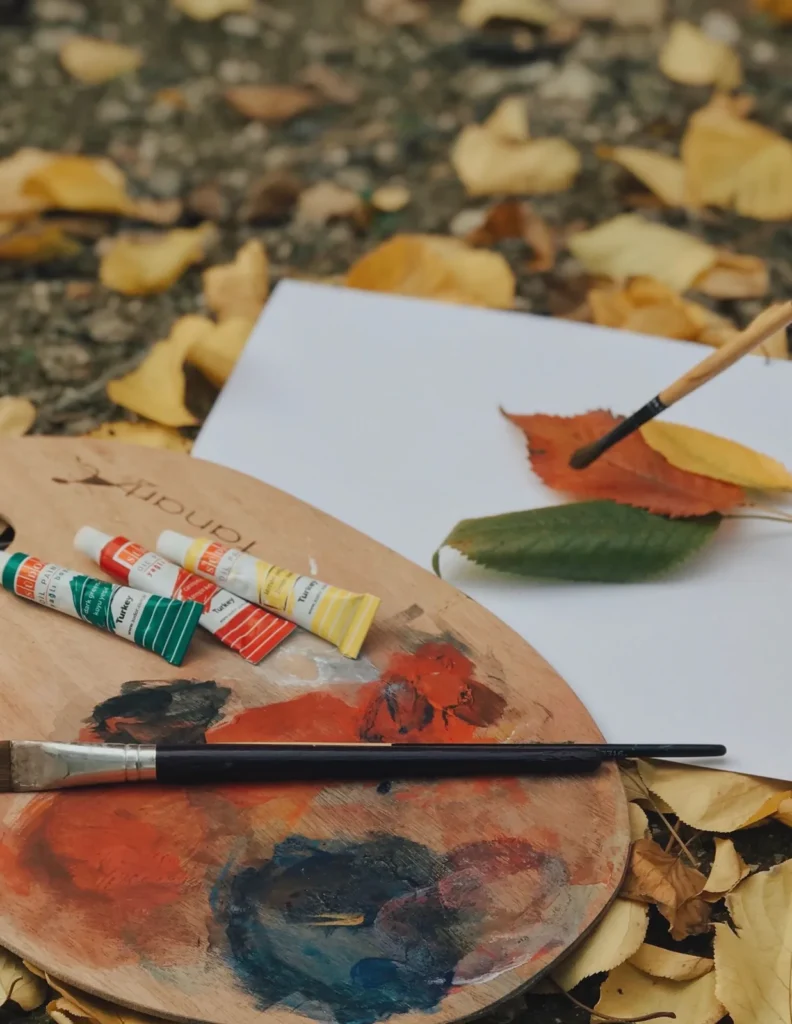 Autumn leaves, paint, and art supplies ready for a fall family art activity