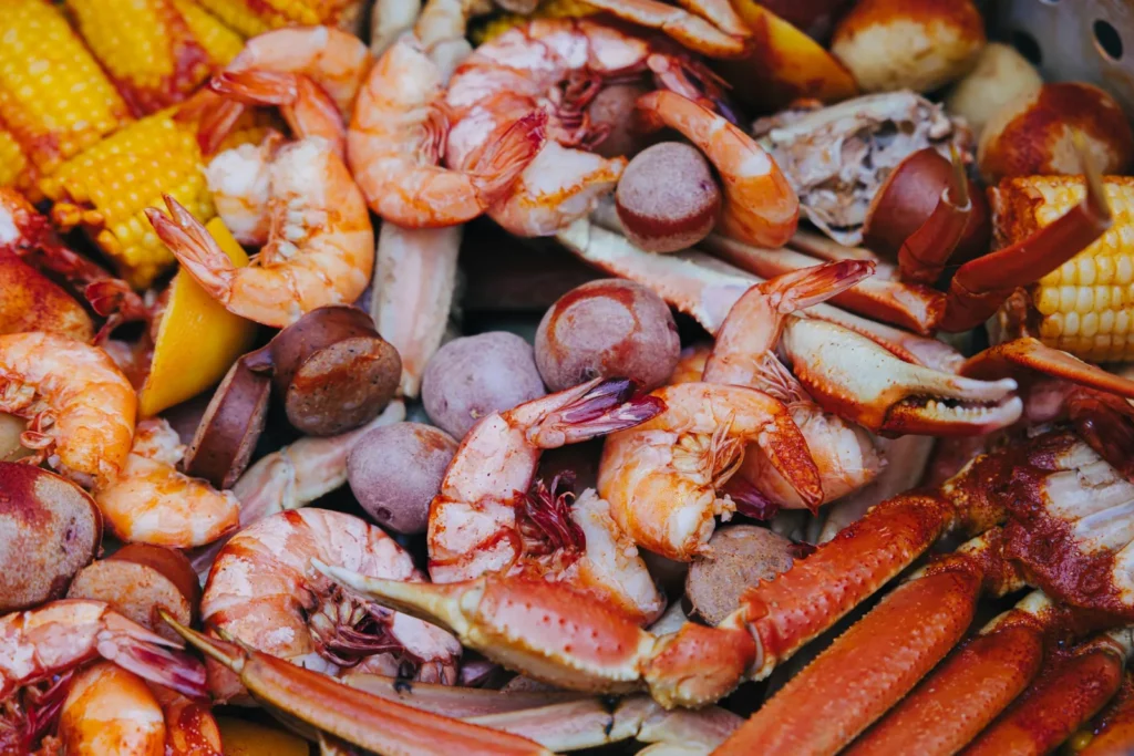 Seafood boil featuring shrimp, crab legs, corn on the cob, potatoes, and sausage.